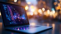 Laptop displaying colorful data visualization charts and graphs on screen with warm bokeh lights in background for business analytics and technology concepts.