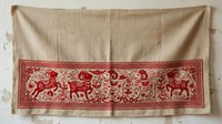 Vintage linen textile with red embroidered border featuring ornamental animals and scrollwork patterns. Traditional folk art design suitable for home decor, upholstery, and craft projects.