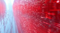 Digital binary code streaming in red and white with motion blur effect creates dynamic technological background for cybersecurity and data concepts.