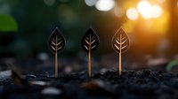 Three wooden leaf-shaped plant markers stand in dark soil against blurred sunset bokeh background, symbolizing growth, gardening and eco-friendly lifestyle.