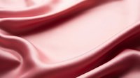 Smooth pink satin fabric with soft flowing waves and elegant folds, creating a luxurious silk texture background for fashion and beauty designs.