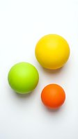 Colorful rubber balls in green, yellow, and orange isolated on white background, ready for design projects, merchandise, and educational materials.