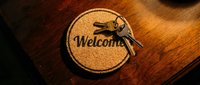 Round cork welcome mat with a bunch of keys on a wooden surface, symbolizing hospitality, new home, rental property, or hotel check-in.