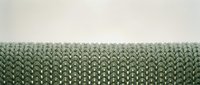 Green knitted fabric texture with detailed stitching pattern on neutral background for textile and craft projects.