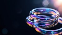 Luminous glass rings with iridescent reflections and bokeh effects on dark background create mesmerizing abstract composition with purple and blue highlights.