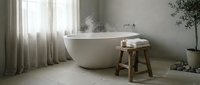 Luxurious freestanding bathtub with steam rising, wooden stool with towels, sheer curtains, potted plants, and minimalist spa bathroom interior design for relaxation and wellness.