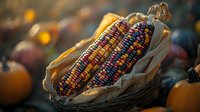 Colorful glass gem corn cobs with vibrant rainbow kernels displayed in rustic basket among autumn pumpkins, dramatic lighting creates harvest season ambiance.