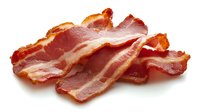 Crispy cooked bacon strips isolated on white background, ready for breakfast menu design, food photography and culinary projects.
