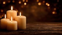 Burning cream candles on wooden surface with warm bokeh lights in dark background creating cozy atmosphere for relaxation or celebration.