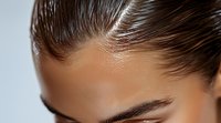 Close up view of well-groomed eyebrow and forehead with smooth tanned skin and slicked back dark hair against light background, beauty and cosmetics concept.
