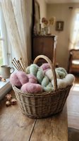 Wicker basket filled with colorful yarn skeins and knitting needles on wooden table in cozy home interior for crafting and hobby projects.