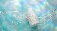 Cosmetic bottle with flowing transparent liquid waves and water droplets against soft blue and turquoise gradient background, suitable for skincare and beauty product marketing.
