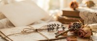 Vintage letters tied with twine, dried flowers, antique keys and old books create nostalgic flat lay composition for romantic correspondence and memory keeping.