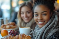 Young African American woman enjoying coffee and pastries with friend at cozy cafe, warm atmosphere for lifestyle and friendship concepts.