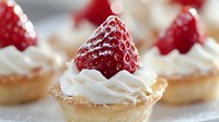 Fresh strawberry tartlets with whipped cream on crisp pastry shells, showcasing bright red berries against creamy white topping for dessert menus.