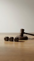 Wooden judge gavel with legal symbol dice on desk representing justice system and court proceedings for law firm presentations.