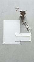 Minimalist white stationery mockup with blank paper, envelope and dried branch in ceramic cup on neutral gray background for branding design.