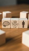 Wooden blocks with brain, hand and human figure symbols representing mind-body connection, holistic health and wellness concepts for therapy and personal development.