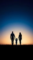 Silhouette of young family holding hands at sunset, walking together through grass field against dramatic sky gradient from deep blue to warm yellow.