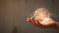 Hand holding glowing sun symbol representing renewable energy, innovation, and sustainable power solutions for business and environmental concepts.