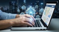 Digital real estate technology concept with hands typing on laptop displaying property search interface and floating house icons for online market.