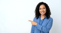 Professional African American businesswoman in blue blazer pointing and smiling on white background for corporate presentations and marketing materials.