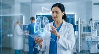 Female Asian doctor examining holographic lung scan in modern medical facility with advanced technology for healthcare diagnosis and treatment.
