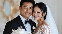 Asian bride and groom in elegant wedding attire share intimate moment. She wears lace dress with veil, he in black tuxedo with bow tie. Romantic wedding portrait.