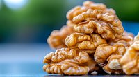 Fresh walnut kernels in macro view showing detailed texture and natural ridges against blurred background, nutritious raw nuts for healthy eating and snacking.