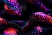Vibrant neon snake skin pattern in pink, purple and blue colors on black background creates abstract macro texture with detailed scales and iridescent effect.