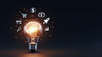Glowing light bulb with business icons representing innovation, entrepreneurship and creative solutions for startup success and financial growth strategies.