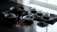 Assorted seeds and grains in bowls and jars on dark slate surface near window. Healthy organic superfood ingredients for cooking and nutrition.