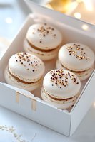 White macarons with gold and bronze sprinkles in gift box. Delicate French almond meringue cookies with festive metallic decoration for special occasions.