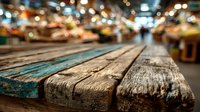 Weathered wooden table surface with blurred colorful market lights creating warm bokeh background for product display and commercial photography.