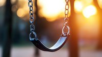 Empty swing at sunset with warm bokeh lights in background creates nostalgic mood, childhood memories concept for emotional storytelling and design projects.