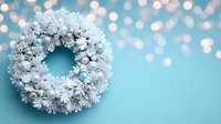 White frosted Christmas wreath on turquoise background with bokeh lights, creating festive holiday atmosphere for seasonal decorations.