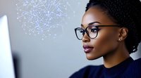 Young African American businesswoman in glasses looking at computer screen with digital network visualization, professional corporate portrait in blue tones.