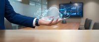 Businessman holding glowing cloud computing hologram with digital icons in modern office, symbolizing data storage and network technology.