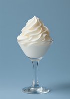 Whipped cream dessert served in elegant glass goblet against soft blue background, perfect for food and beverage marketing.