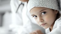 Young girl wearing white headscarf in hospital setting looks at camera with hopeful expression, soft focus medical environment creates emotional healthcare narrative.