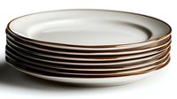 Stack of clean white ceramic dinner plates with copper trim edge against dark background, minimalist tableware for modern dining and restaurant service.
