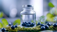Fresh blueberries in glass jar surrounded by moss and green leaves on natural background for healthy eating and organic food concepts.