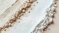 Cosmetic powder foundation makeup swatches in neutral beige tones scattered on white surface for beauty and skincare product testing applications.