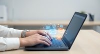 Professional businesswoman typing on laptop with digital communication icons floating above keyboard in modern office workspace for technology concepts.