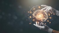 Hands holding glowing brain with golden light particles and neural connections, representing artificial intelligence, innovation, and digital technology for business and science concepts.