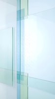 Layered translucent glass panels in soft blue and green tones create an abstract architectural composition with overlapping geometric forms and light reflections.