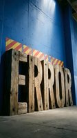 Wooden sign with ERROR text in large rustic letters against blue wall with red and yellow striped banner above, suitable for error pages, warning concepts, and design projects.