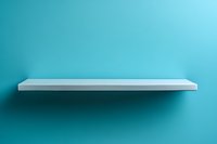 Empty white floating shelf on turquoise wall background with soft shadow, minimalist modern interior design element for product display and decoration.