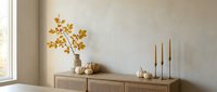 Minimalist wooden sideboard with autumn branch decoration and brass candlesticks in modern neutral interior design for home decor inspiration.