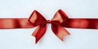 Red satin ribbon bow on white background isolated for gift wrapping, holiday decorations and festive design projects.